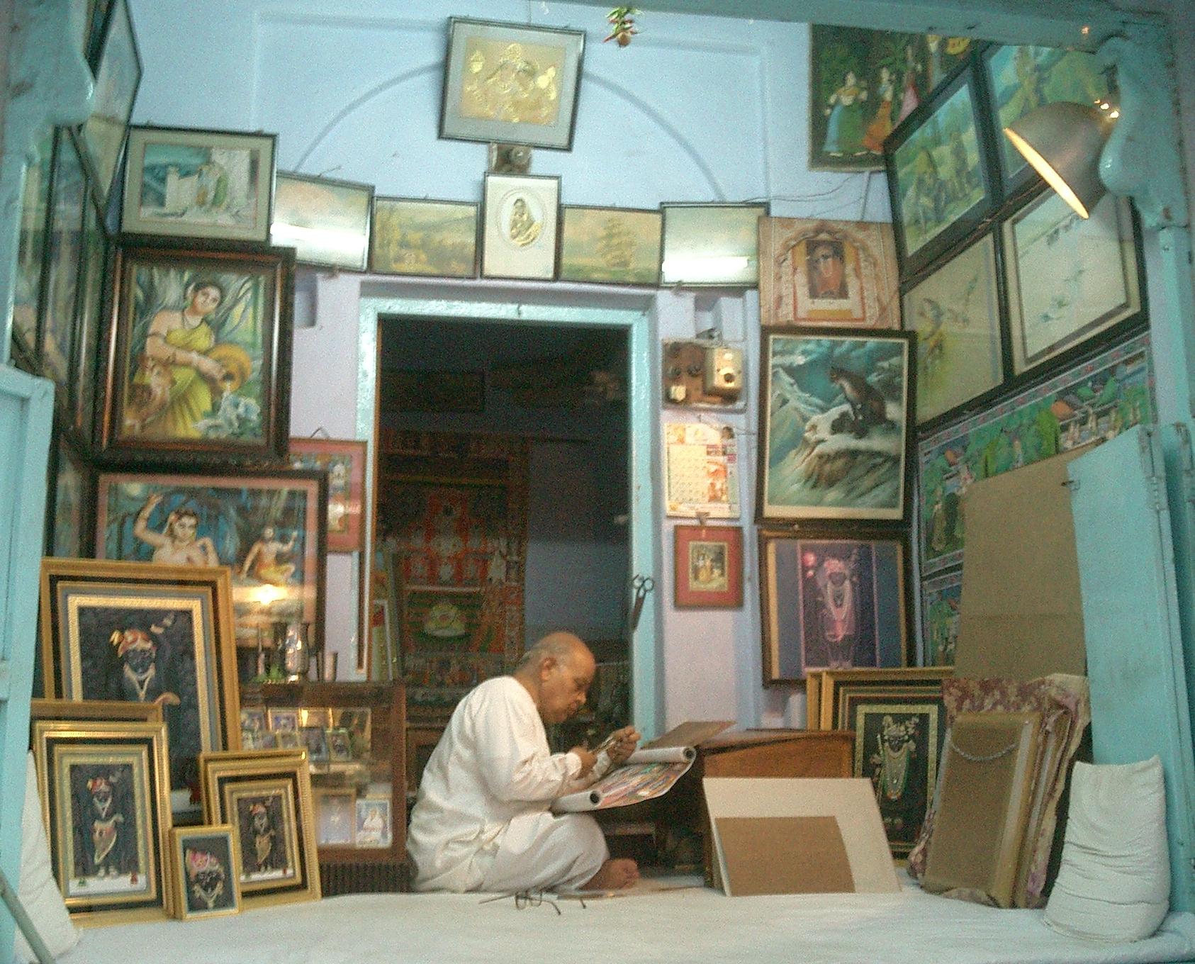 File:Painter at work, Nathdwara.jpg - a man sitting on a bed with a laptop