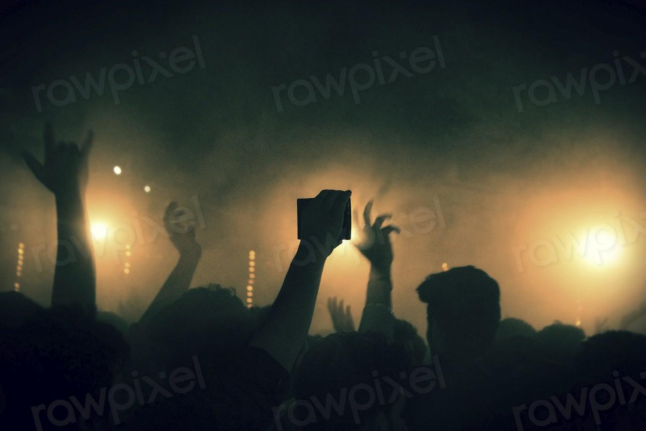 Free concert image - a crowd of people at a concert with their hands up