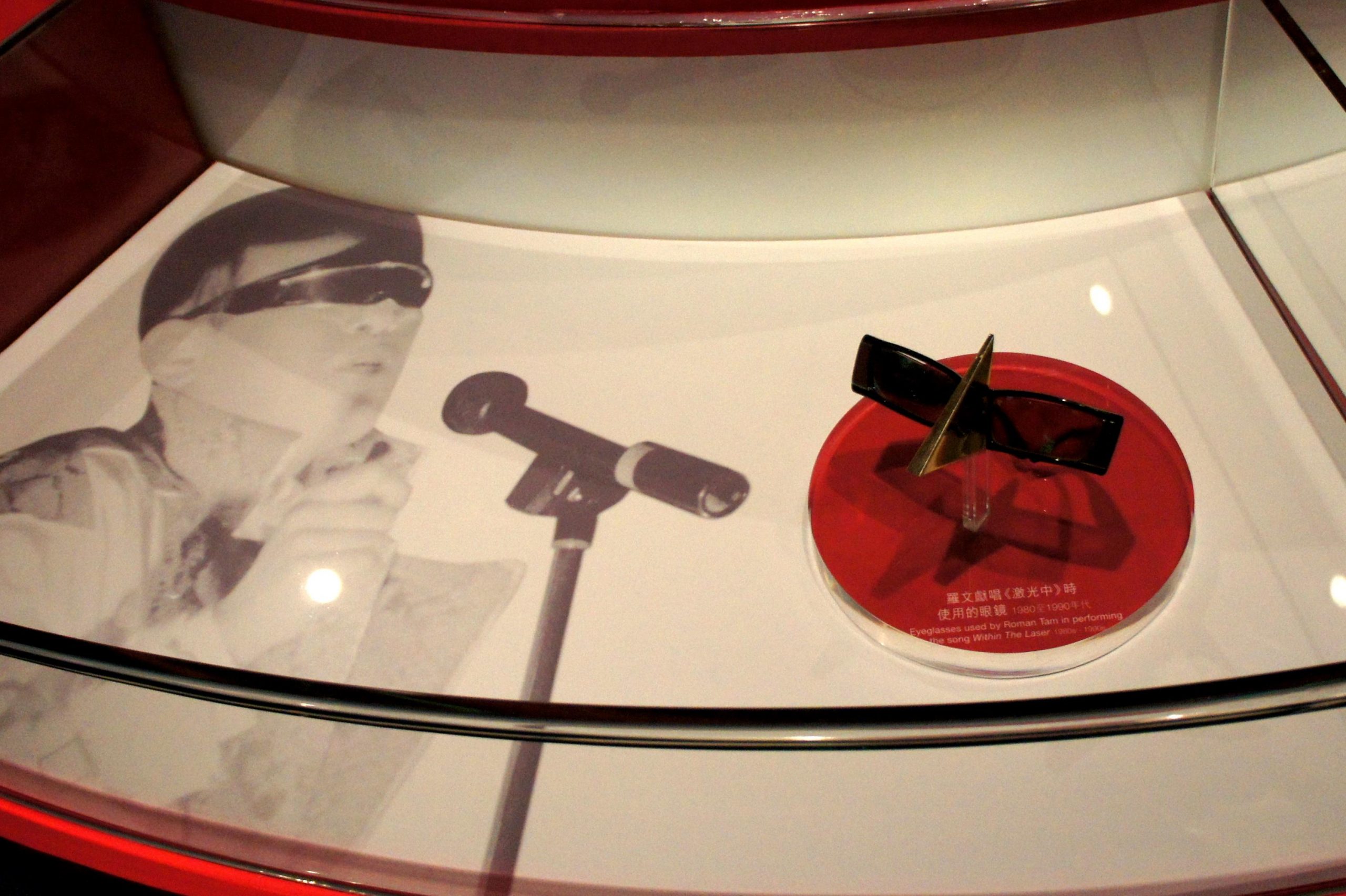 HKHM - Applauding to Hong Kong Pop Legend - Roman Tam eyeglasses (Hong Kong) - a red and white displ